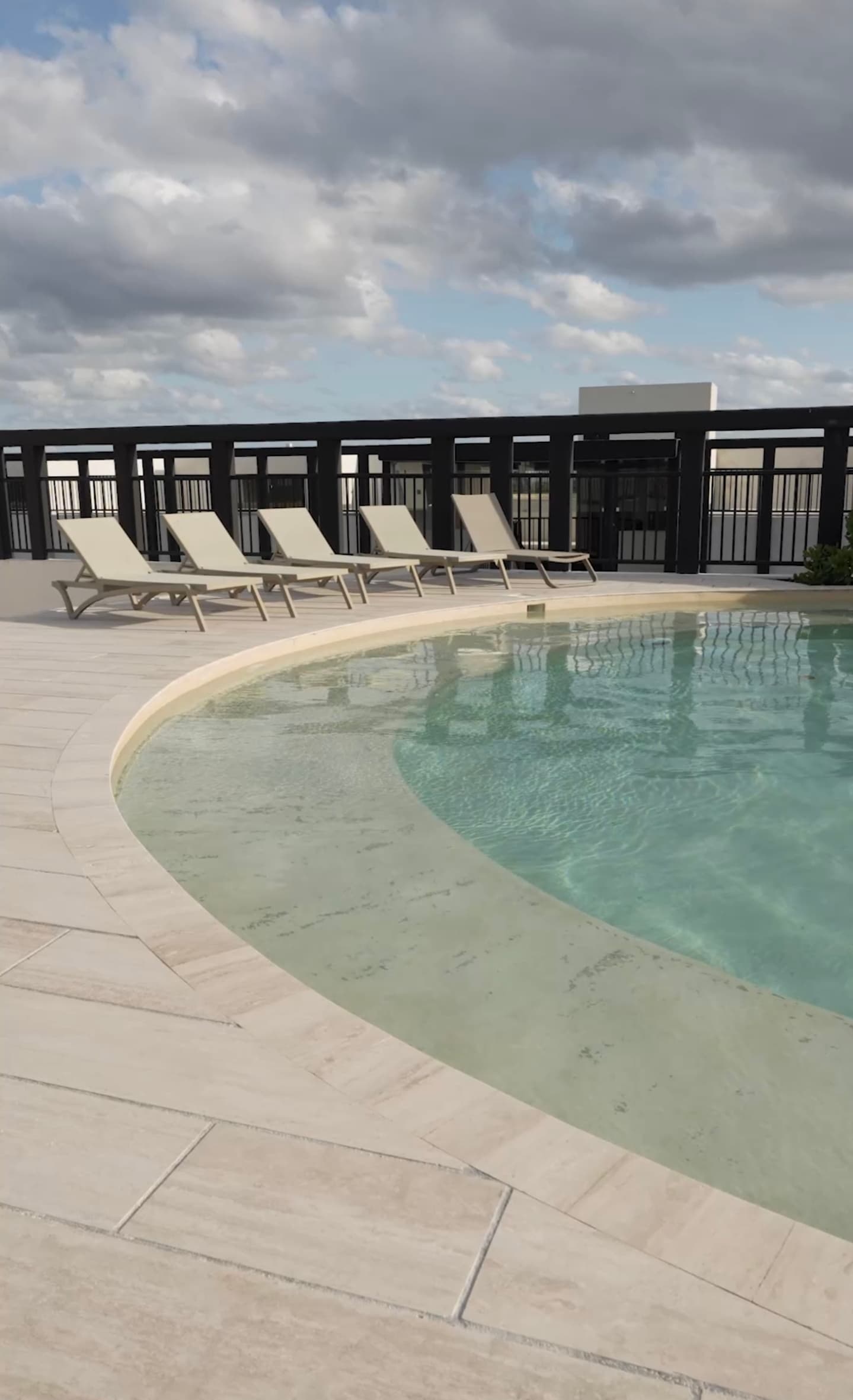 Shared swimming pool with lounge area and jungle backdrop